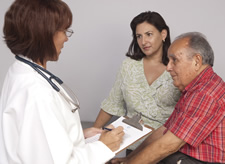doctor talking to caregiver and elderly man