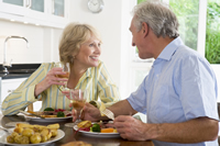 happy elderly couple eating dinner