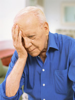 elderly man holding head in hand